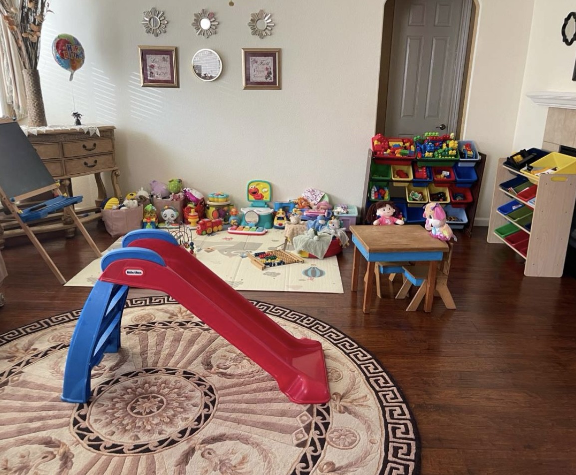 Toddler playroom with toys, a small table, and an indoor slide